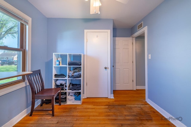 sitting room featuring wood finished floors, a ceiling fan, and baseboards