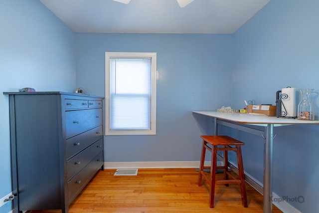 bar area featuring light wood-style floors and baseboards