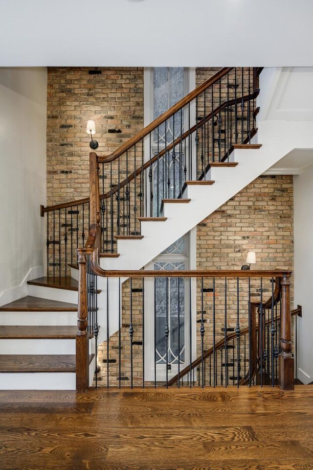2054 N Mohawk St, Chicago, IL 60614 - stairway with wood finished floors, brick wall, and a towering ceiling