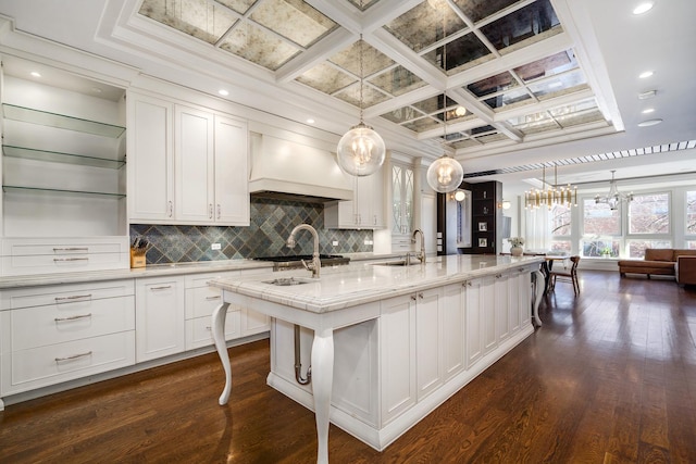 2054 N Mohawk St, Chicago, IL 60614 - kitchen featuring coffered ceiling, custom range hood, backsplash, white cabinets, and a center island with sink