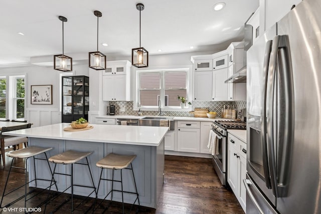 4328 N Ridgeway Ave, Chicago, IL 60618 - kitchen with stainless steel appliances, a breakfast bar area, light countertops, a kitchen island, and backsplash