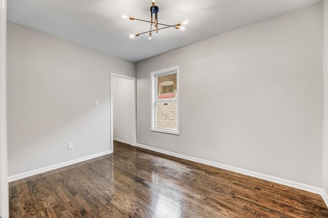 8109 S Marquette Ave, Chicago, IL 60617 - empty room featuring a chandelier, baseboards, and dark wood finished floors