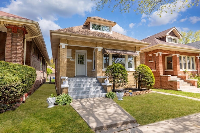 8109 S Marquette Ave, Chicago, IL 60617 - view of front of home with brick siding, a front yard, roof with shingles, and a porch