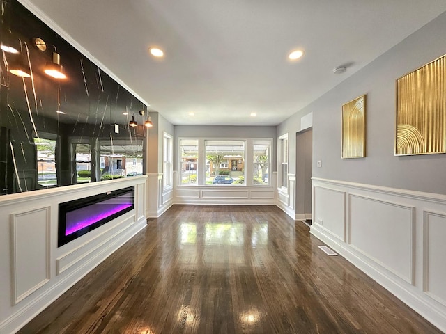 8109 S Marquette Ave, Chicago, IL 60617 - unfurnished living room with a decorative wall, wood finished floors, recessed lighting, a glass covered fireplace, and a wainscoted wall