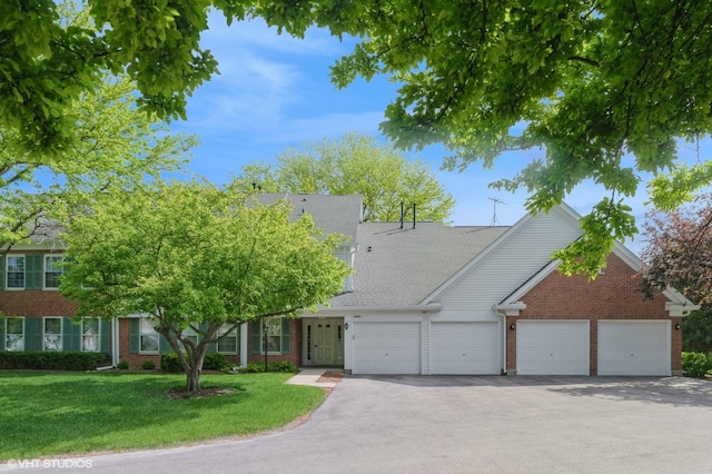 803 Persimmon Ln Unit A, Mount Prospect, IL 60056 - view of front facade with brick siding, an attached garage, driveway, and a front lawn