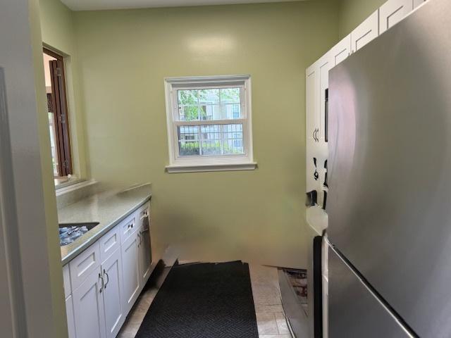 803 Persimmon Ln Unit A, Mount Prospect, IL 60056 - kitchen with freestanding refrigerator, white cabinets, and light countertops