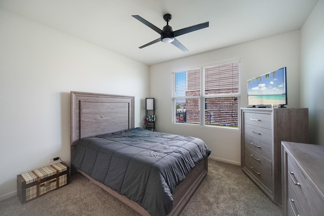 bedroom with light colored carpet, baseboards, and a ceiling fan