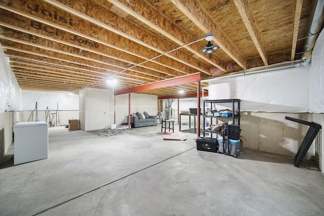 unfinished below grade area featuring fridge