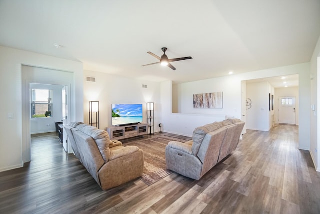living area featuring wood finished floors, a ceiling fan, healthy amount of natural light, and baseboards