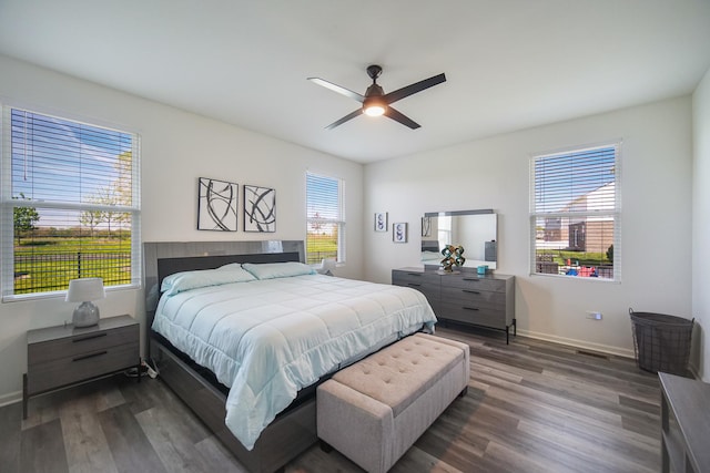 bedroom with dark wood-style flooring, baseboards, and a ceiling fan