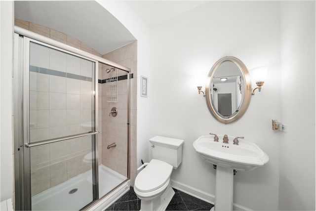 bathroom featuring baseboards, a stall shower, and toilet