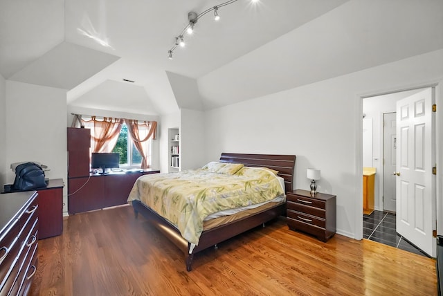 bedroom featuring wood finished floors and vaulted ceiling