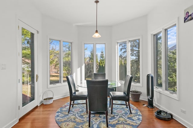 sunroom / solarium featuring a wooden deck, wood finished floors, and baseboards