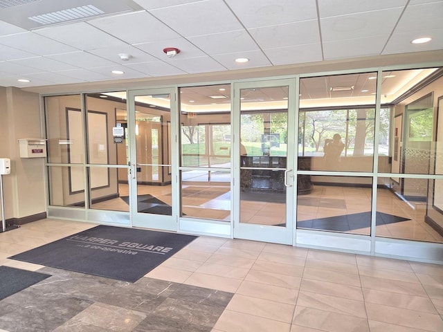 doorway featuring plenty of natural light, a drop ceiling, baseboards, and recessed lighting