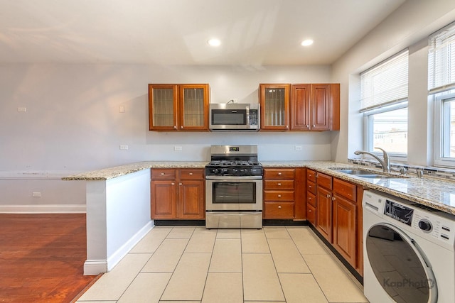 4006 W Nelson St Unit 6A, Chicago, IL 60641 - kitchen with stainless steel appliances, washer / clothes dryer, a sink, brown cabinetry, and recessed lighting