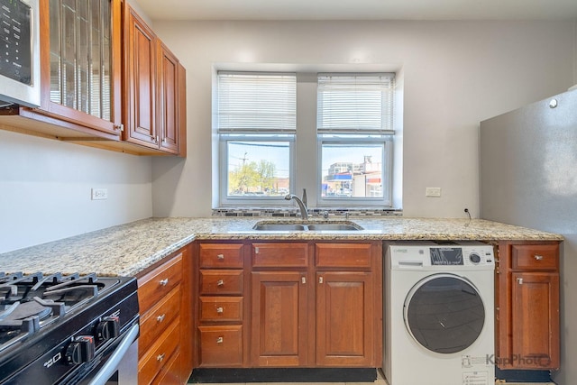 4006 W Nelson St Unit 6A, Chicago, IL 60641 - kitchen with washer / clothes dryer, appliances with stainless steel finishes, a sink, and light stone counters