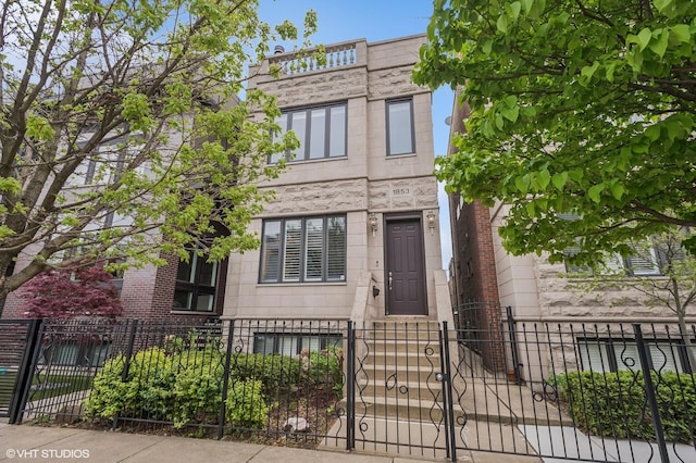 view of front facade featuring a fenced front yard, stone siding, and a gate
