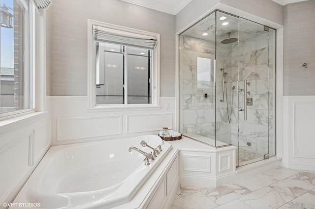 full bathroom with a decorative wall, a bath, wainscoting, a stall shower, and marble look tile flooring