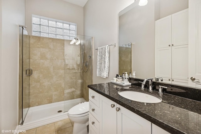full bathroom with a shower stall, tile patterned flooring, toilet, and vanity
