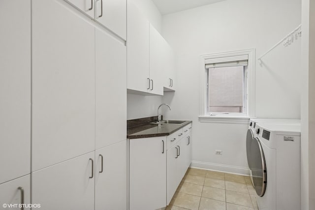 laundry area with cabinet space, washer and dryer, baseboards, and light tile patterned flooring