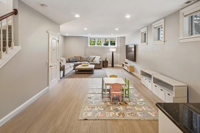 living room featuring light wood-type flooring, stairs, recessed lighting, and baseboards