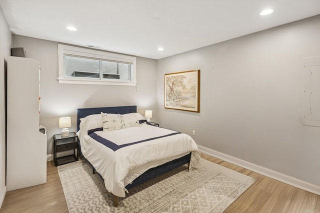 bedroom featuring light wood finished floors, baseboards, and recessed lighting