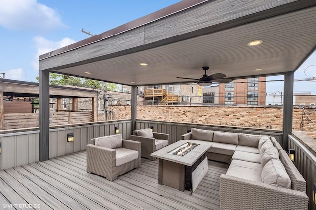 wooden terrace featuring an outdoor living space with a fire pit and fence