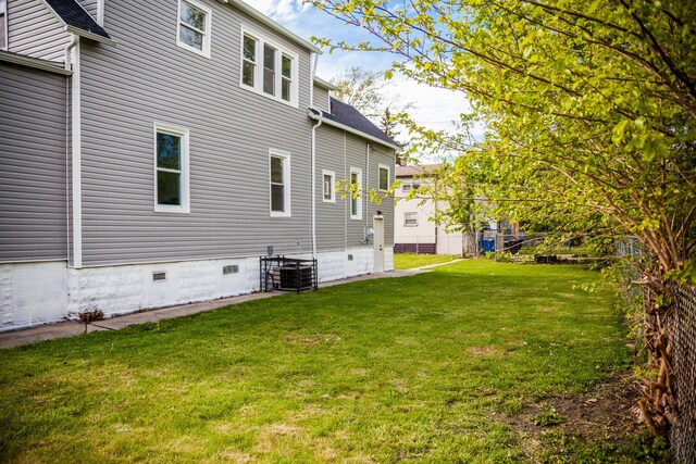 118 W 118th St, Chicago, IL 60628 - back of property with a yard, crawl space, roof with shingles, and central AC