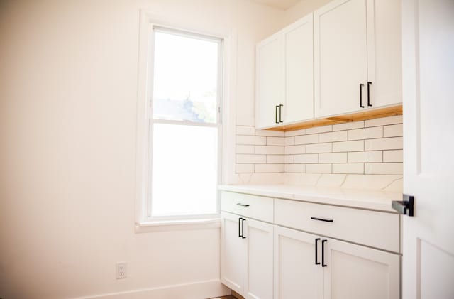 118 W 118th St, Chicago, IL 60628 - kitchen with backsplash, healthy amount of natural light, and white cabinetry