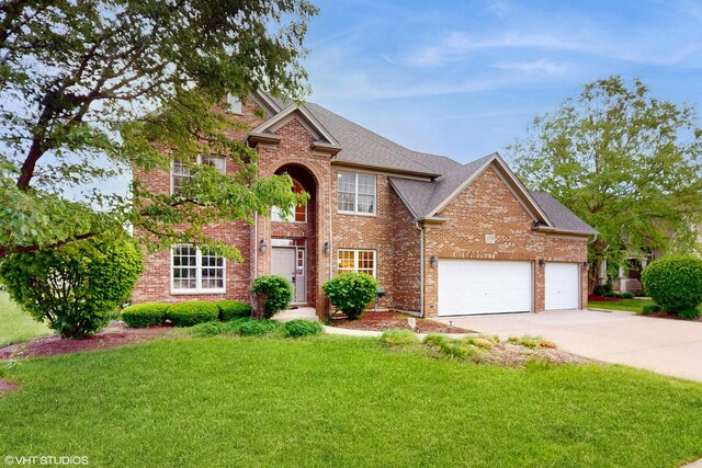 traditional home with driveway, brick siding, a front yard, and an attached garage