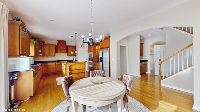 dining room with light wood-type flooring, a chandelier, stairway, baseboards, and recessed lighting