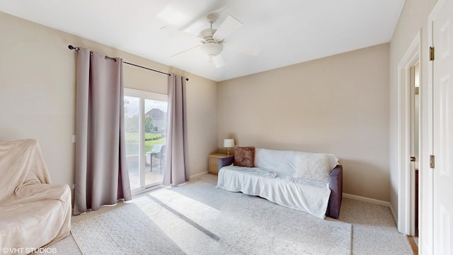 living area with carpet flooring, baseboards, and ceiling fan