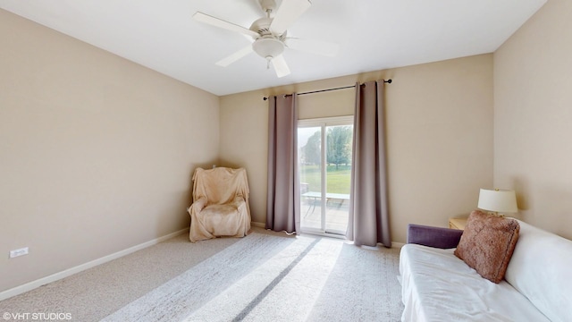 living area featuring carpet flooring, baseboards, and ceiling fan
