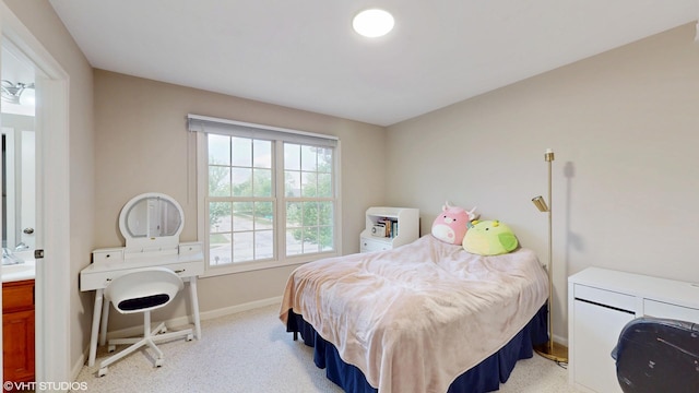 bedroom with baseboards and light carpet