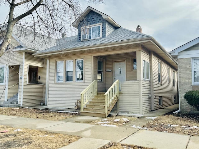 5343 W Warwick Ave, Chicago, IL 60641 - view of front of house featuring roof with shingles, entry steps, and a chimney