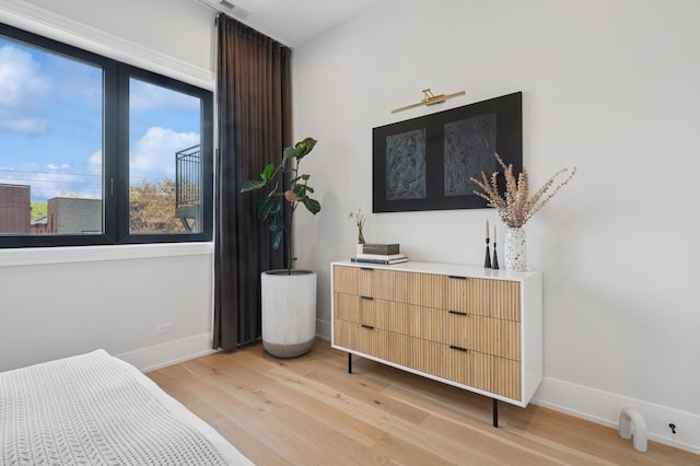 bedroom with light wood finished floors and baseboards