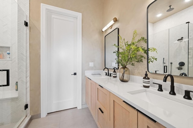 full bathroom with a shower stall, double vanity, tile patterned flooring, and baseboards