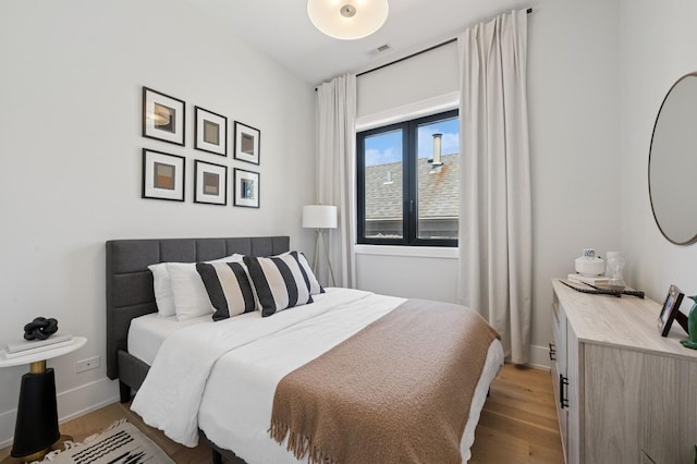 bedroom featuring light wood-style flooring and baseboards
