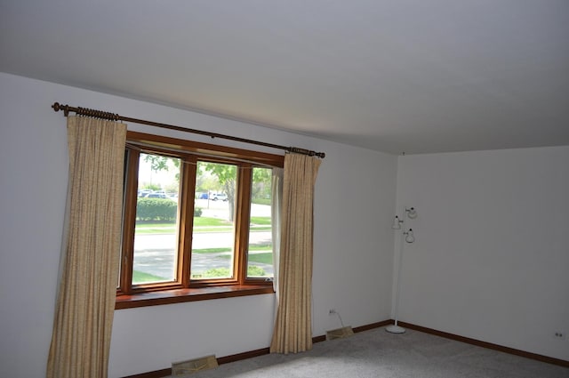 empty room featuring light colored carpet and baseboards