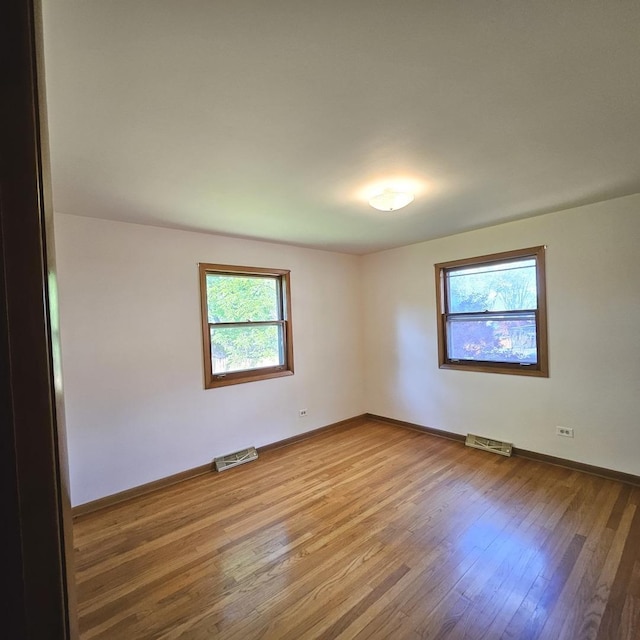 empty room featuring wood finished floors and baseboards