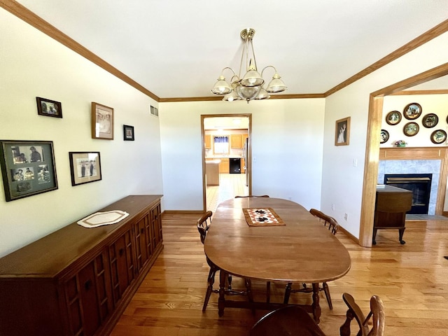 80 N 14th Rd, Lostant, IL 61334 - dining room with wood finished floors, a chandelier, crown molding, a fireplace, and baseboards
