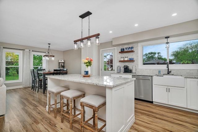 424 Falcon Ridge Way, Bolingbrook, IL 60440 - kitchen with dishwasher, light wood-style flooring, a sink, a center island, and white cabinetry