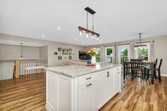 424 Falcon Ridge Way, Bolingbrook, IL 60440 - kitchen featuring light wood finished floors, white cabinetry, a center island, pendant lighting, and light stone counters