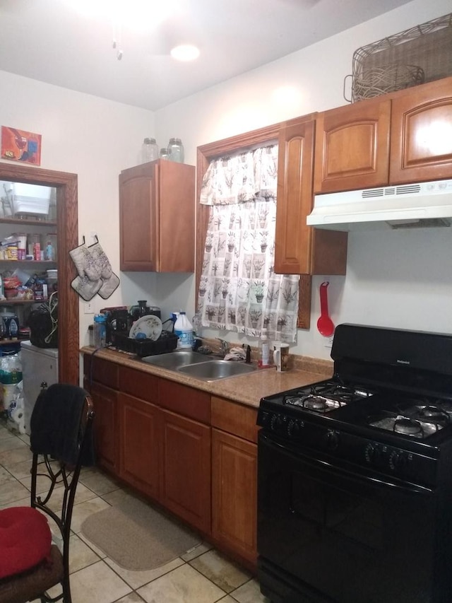 8015 S May St, Chicago, IL 60620 - kitchen with gas stove, under cabinet range hood, a sink, light tile patterned flooring, and light countertops