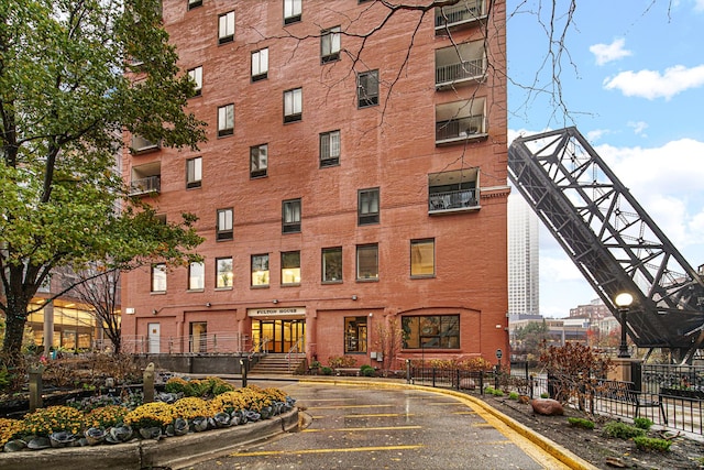 view of property featuring fence and uncovered parking