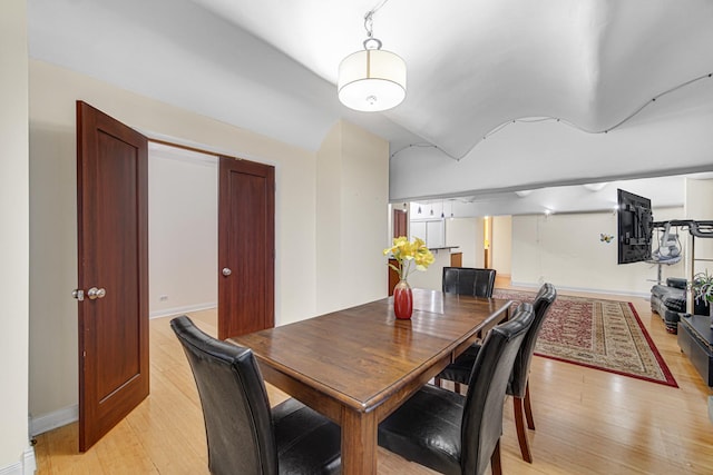 dining space featuring light wood-type flooring and baseboards