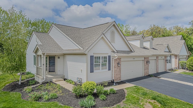 view of front of property with driveway, a shingled roof, brick siding, and a garage