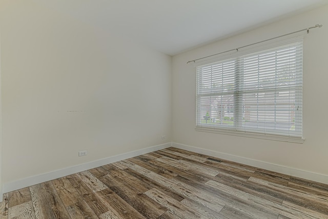 spare room with wood finished floors and baseboards