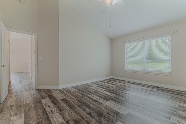 unfurnished room featuring lofted ceiling, wood finished floors, a ceiling fan, and baseboards