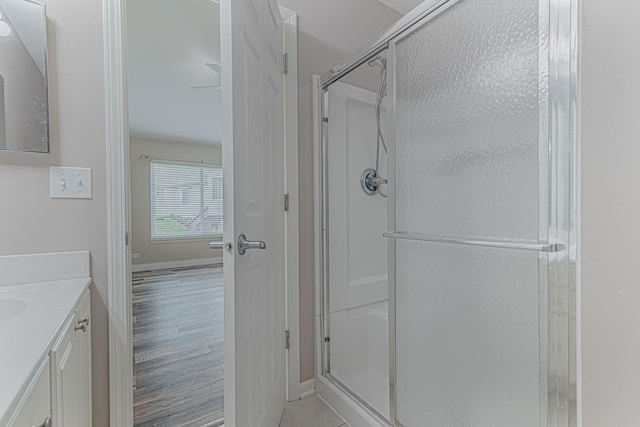 full bath featuring a shower stall, baseboards, and vanity